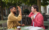 Two men high fiving.