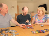 Martin and Liz supporting their son with learning disabilities play with his toy cars. 
