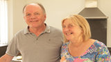Martin and Liz smiling at the camera in their kitchen. 