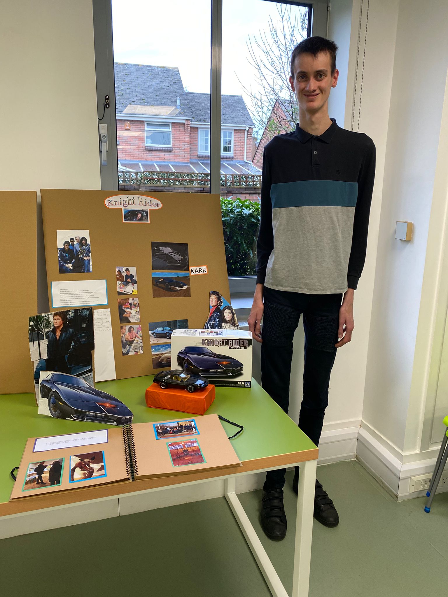 Nathan stood with his display for college. He's made an exhibit for Knight Rider.  It has display items and a model car.