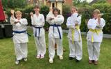 A group of women dressed ready to do martial arts. 