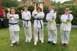 A group of women dressed ready to do martial arts. 