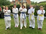 A group of women dressed ready to do martial arts. 