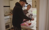 Female Shared Lives carer and young male person we support in the kitchen together, smiling. 