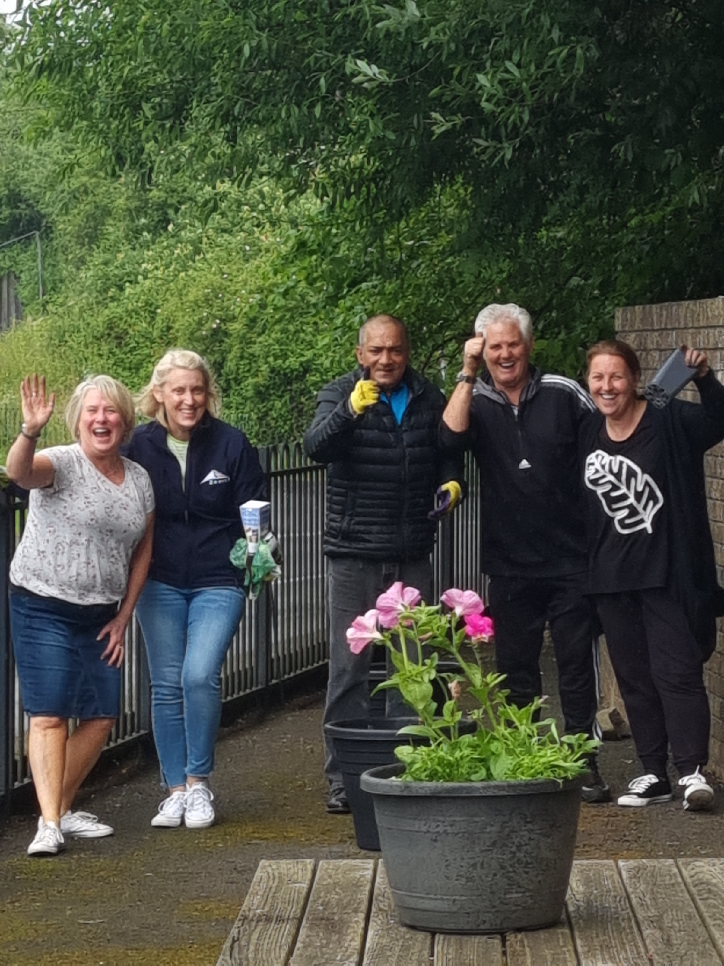 People waving and giving a thumbs up at the camera.