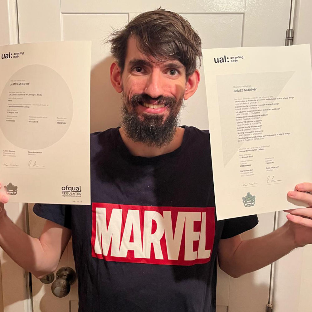 James pictured holding his Level 1 and Level 2 certificate