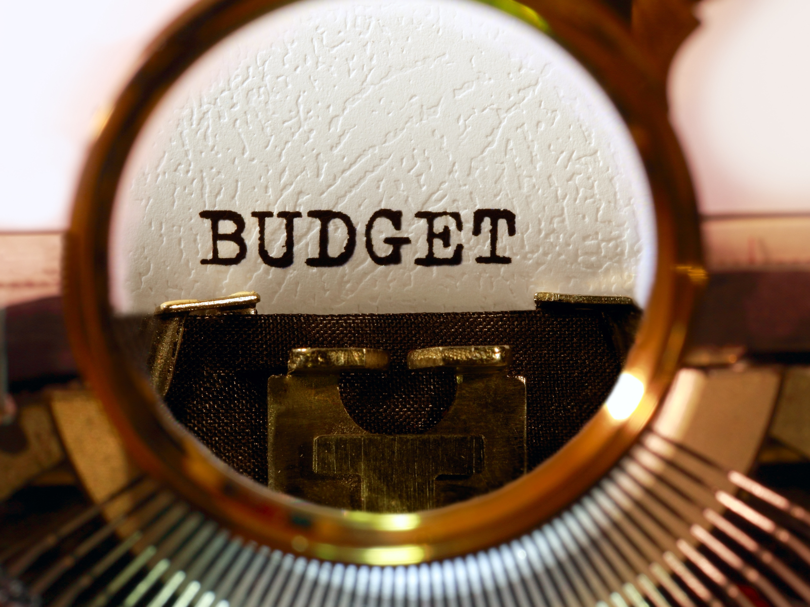 Budget written on typewriter under magnifying glass.