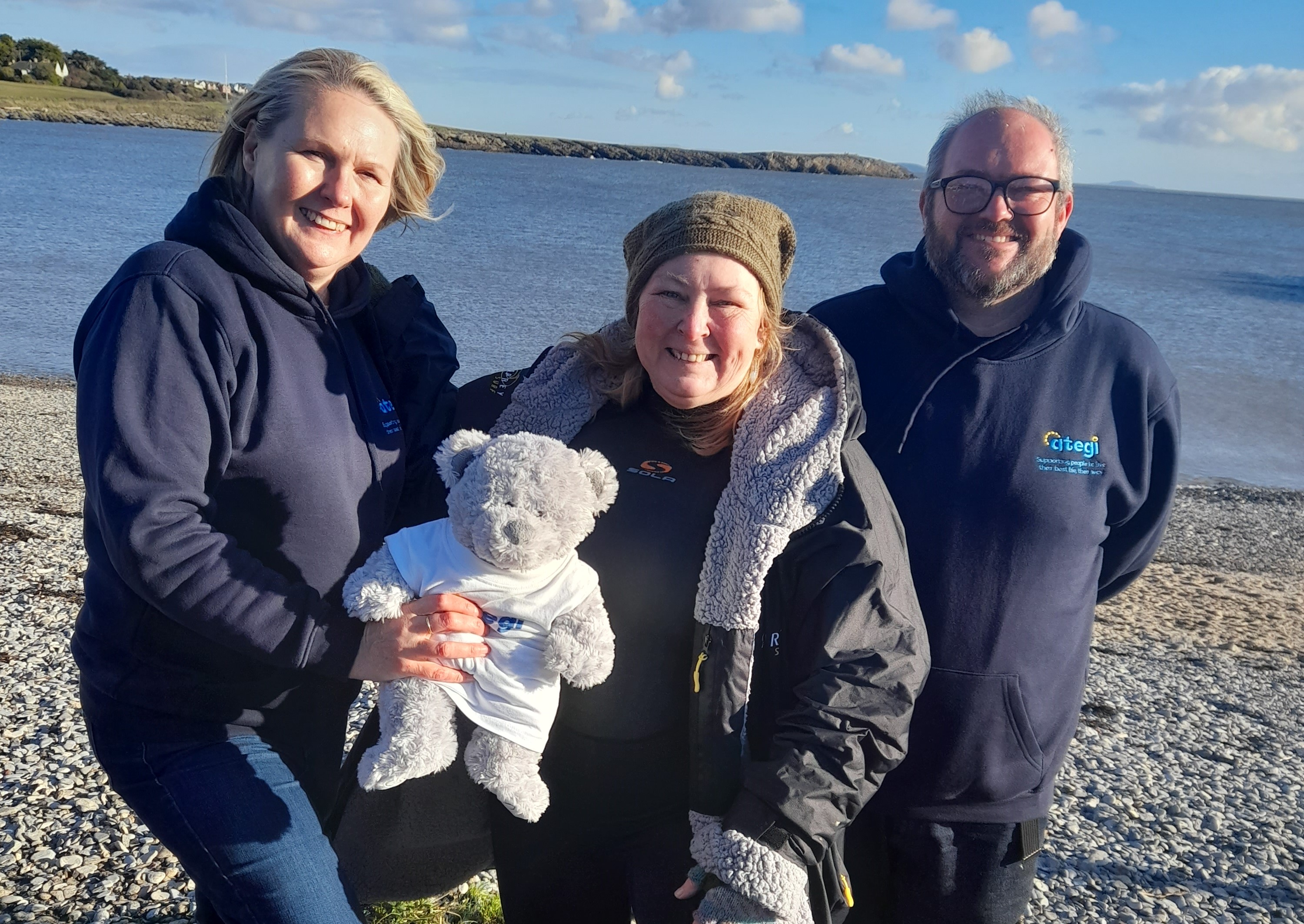 Sheleagh standing on Barry beach with two colleagues and a teddy.