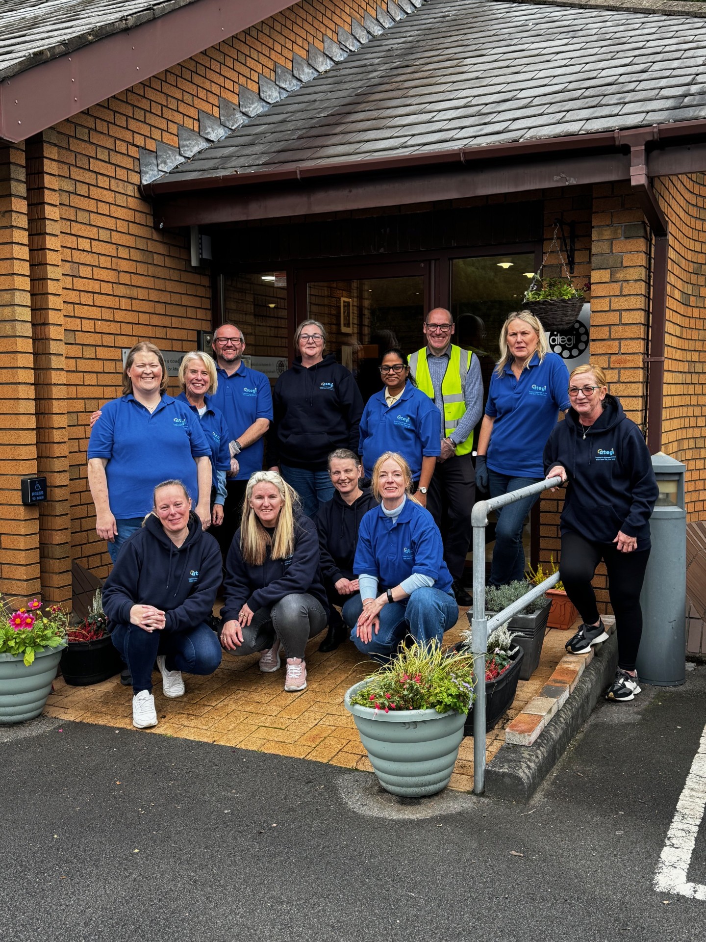 A group of adults standing outside a brick building