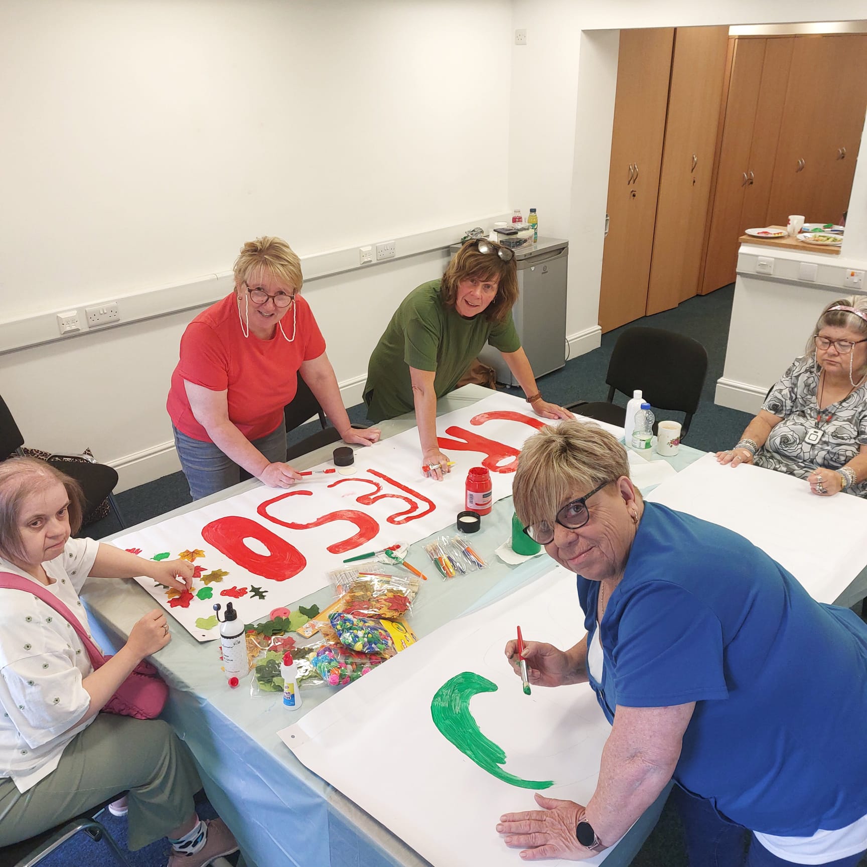 People we support making banners with their support workers for Eisteddfod.