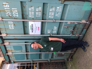 Chif volunteers for WorkAid. Here he is with the container named after him.